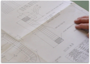 person laying out blue prints for custom coil design